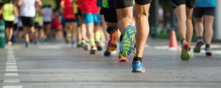 Marathon running race, people feet on city road Orthopedic Specialist in Fairfax VA treating runners, walkers and other atheletes